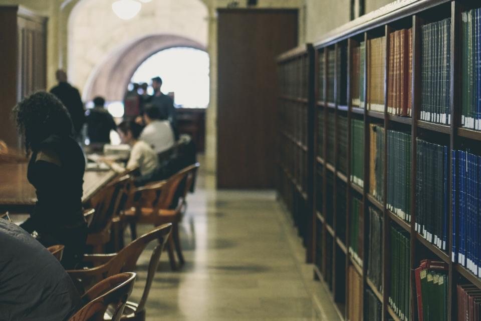Students studying at tables in a college library