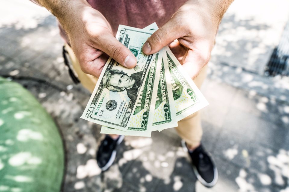 Hands holding a fan of US dollar bills